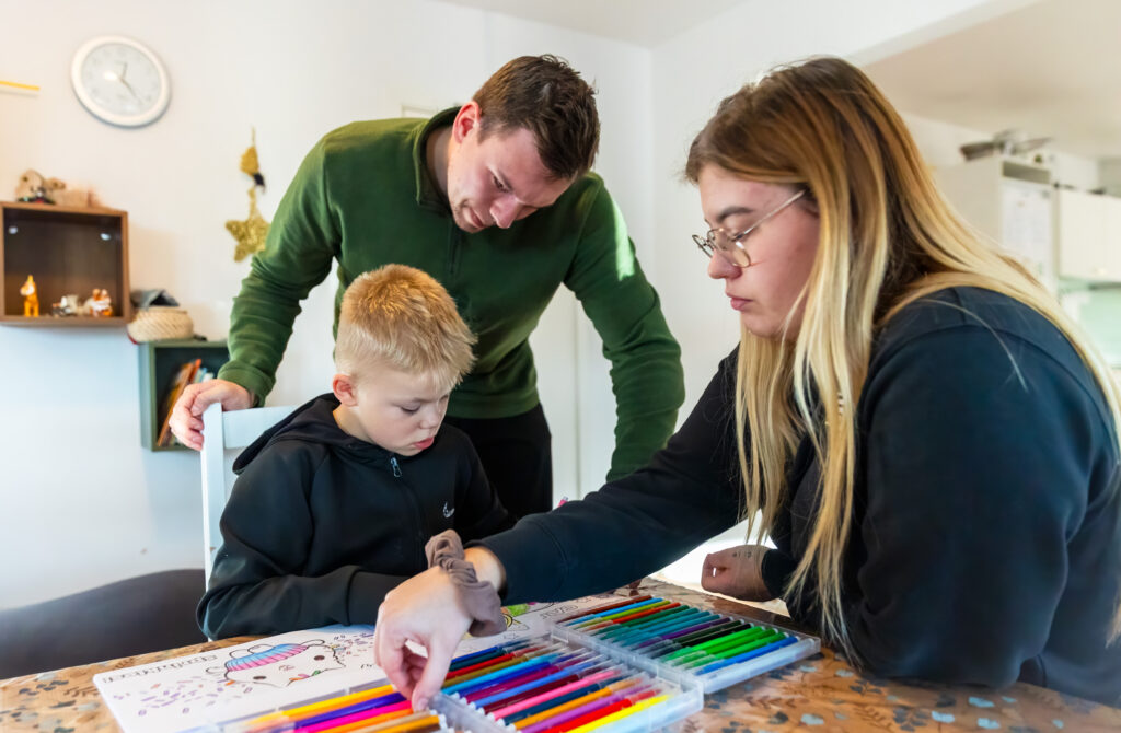 En elev og to lærere tegner i malebog